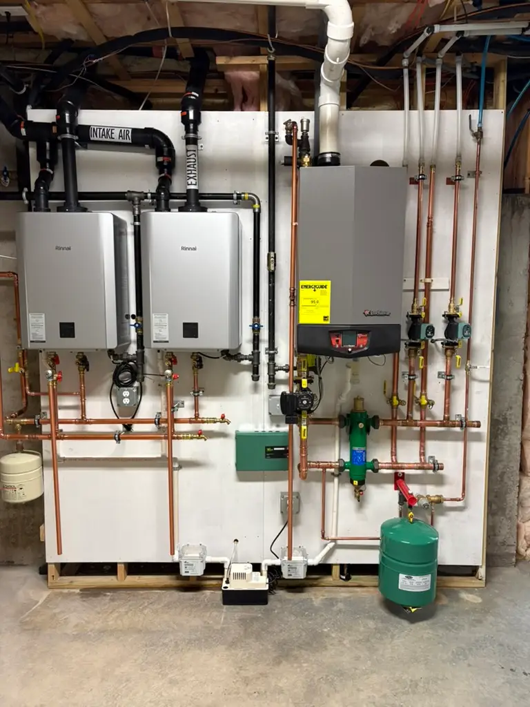 Completed wall-mounted tankless heating system with copper piping and expansion tank