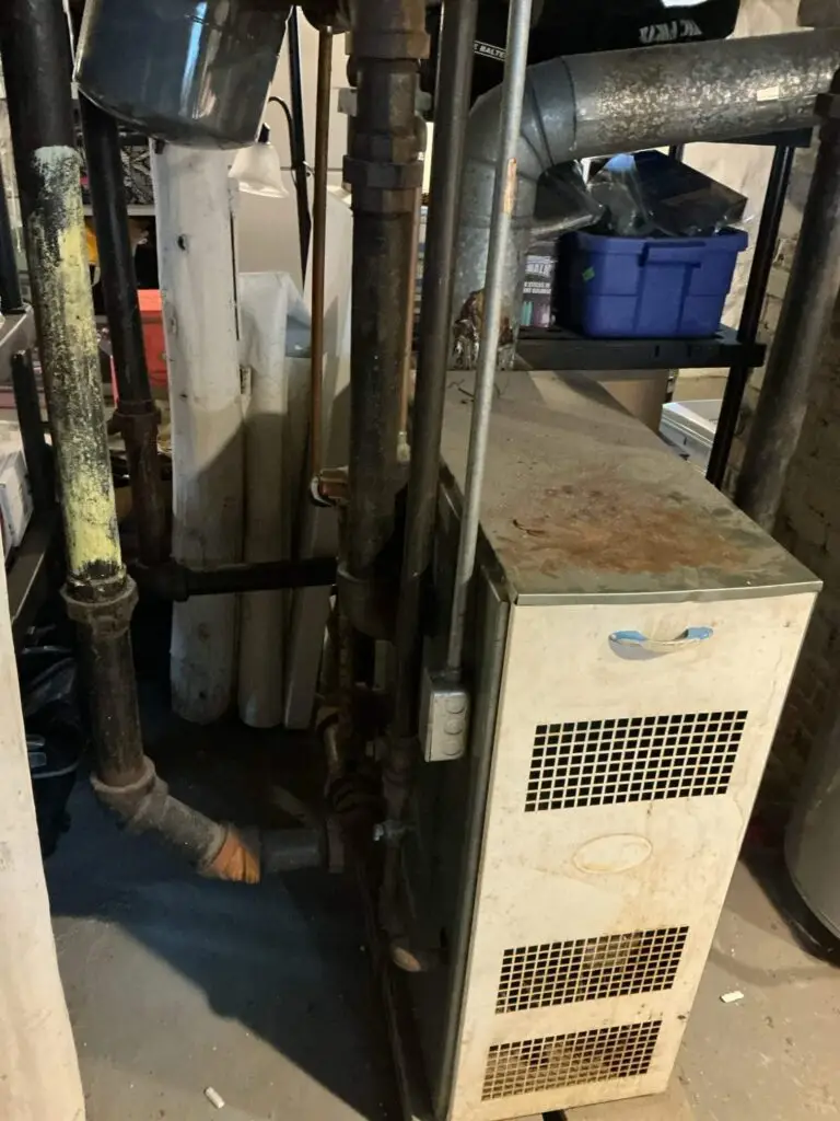 Old basement boiler and heating pipe system before a modern equipment upgrade