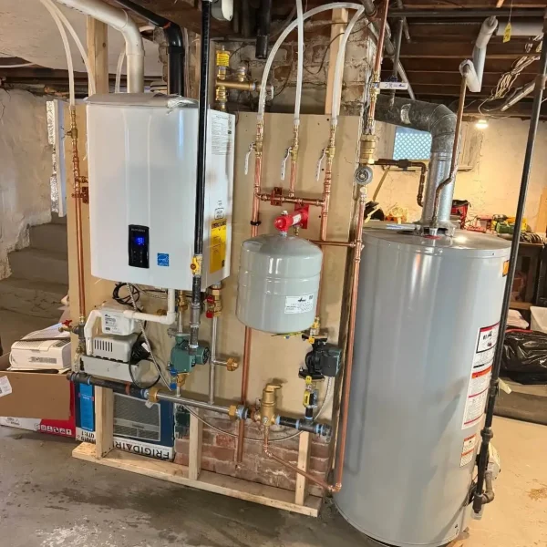 New wall-mounted boiler and hot water tank installation with copper piping and expansion tanks