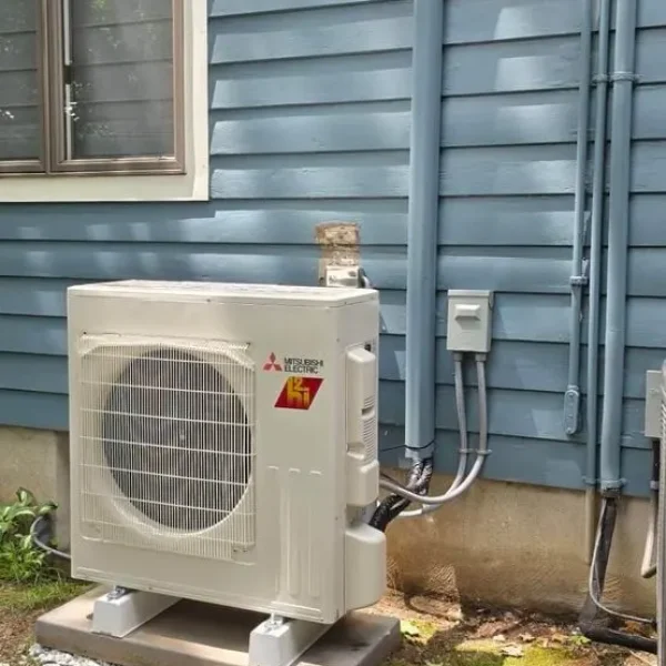Wall-mounted ductless mini-split system installed between two living room windows